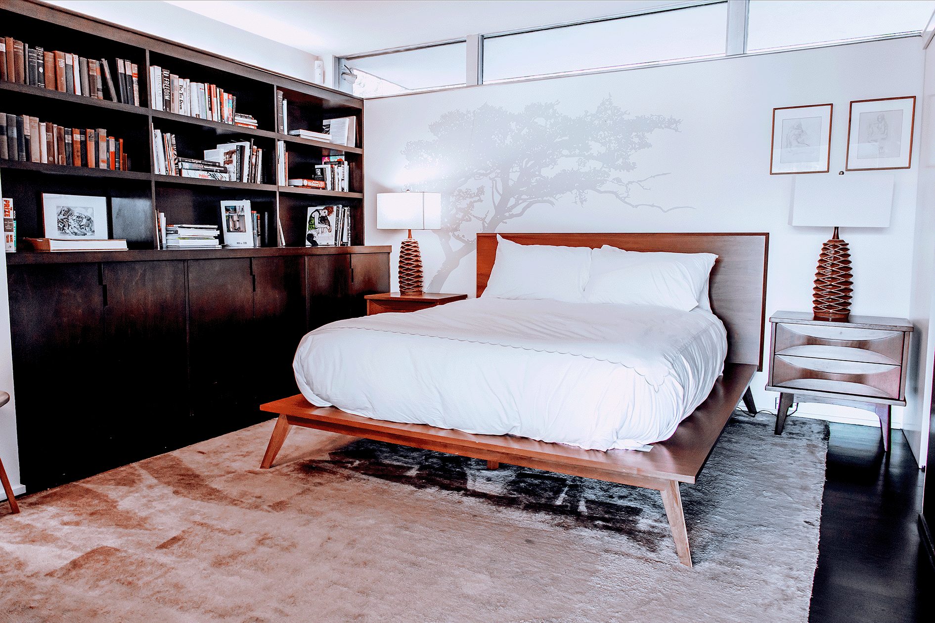 A bed with white sheets and pillows in a bedroom.