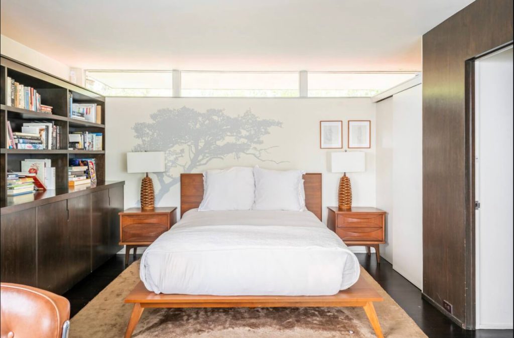 A bed room with a white bed and two nightstands