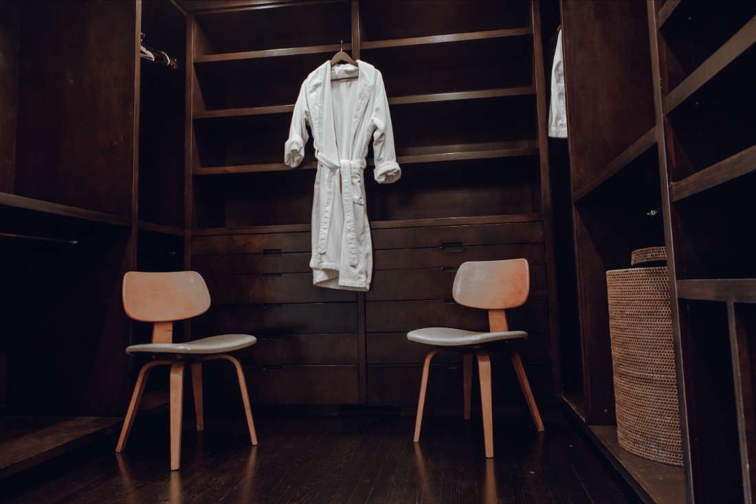 A white robe hanging in the corner of a room.