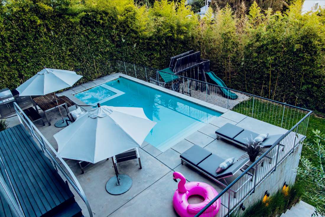 A pool with an umbrella and some chairs