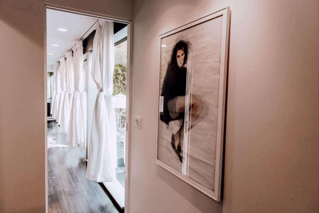 A picture of a woman in a dress hanging on the wall.