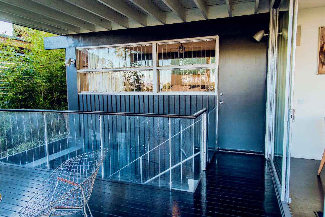 A balcony with glass railings and wooden floors.