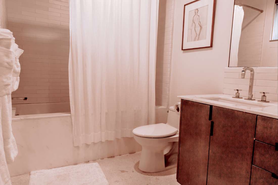 A bathroom with white tile floors and walls.