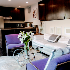 A living room with purple chairs and white furniture.