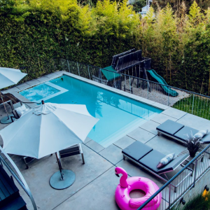 A pool with an umbrella and some chairs