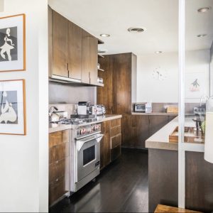 A kitchen with wooden cabinets and white walls.