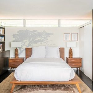 A bed room with a white bed and two night stands
