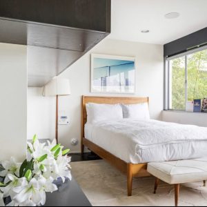 A bedroom with white walls and furniture.