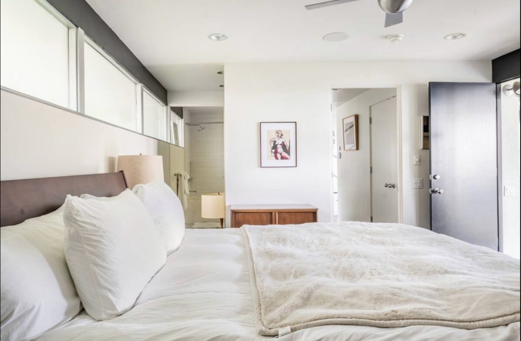 A bedroom with white walls and a large bed.