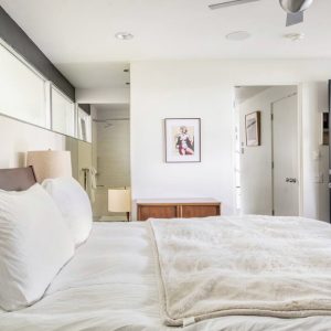 A bedroom with white walls and a large bed.