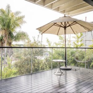 A patio umbrella is sitting on the deck.