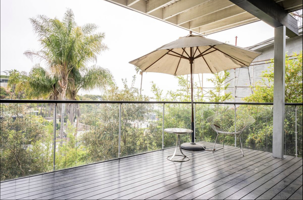 A patio umbrella is sitting on the deck.
