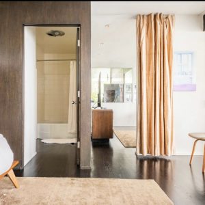 A room with a door open and a table in the middle.