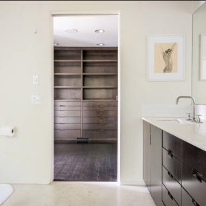 A bathroom with a large mirror and wooden shelves.