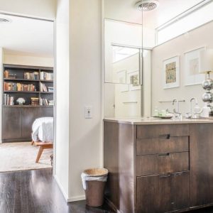 A bathroom with a large mirror and wooden cabinets.