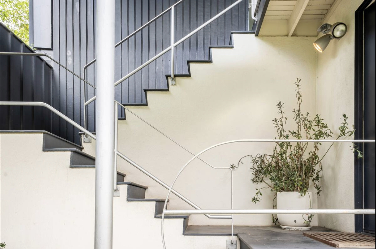 A staircase with metal handrails and white steps.