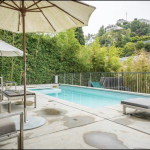 A pool with umbrellas and chairs around it