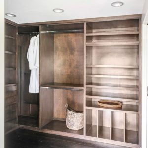 A closet with shelves and clothes hanging on it.
