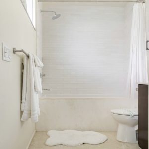 A bathroom with white walls and a toilet