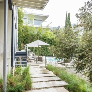 A walkway leading to the pool of a house.